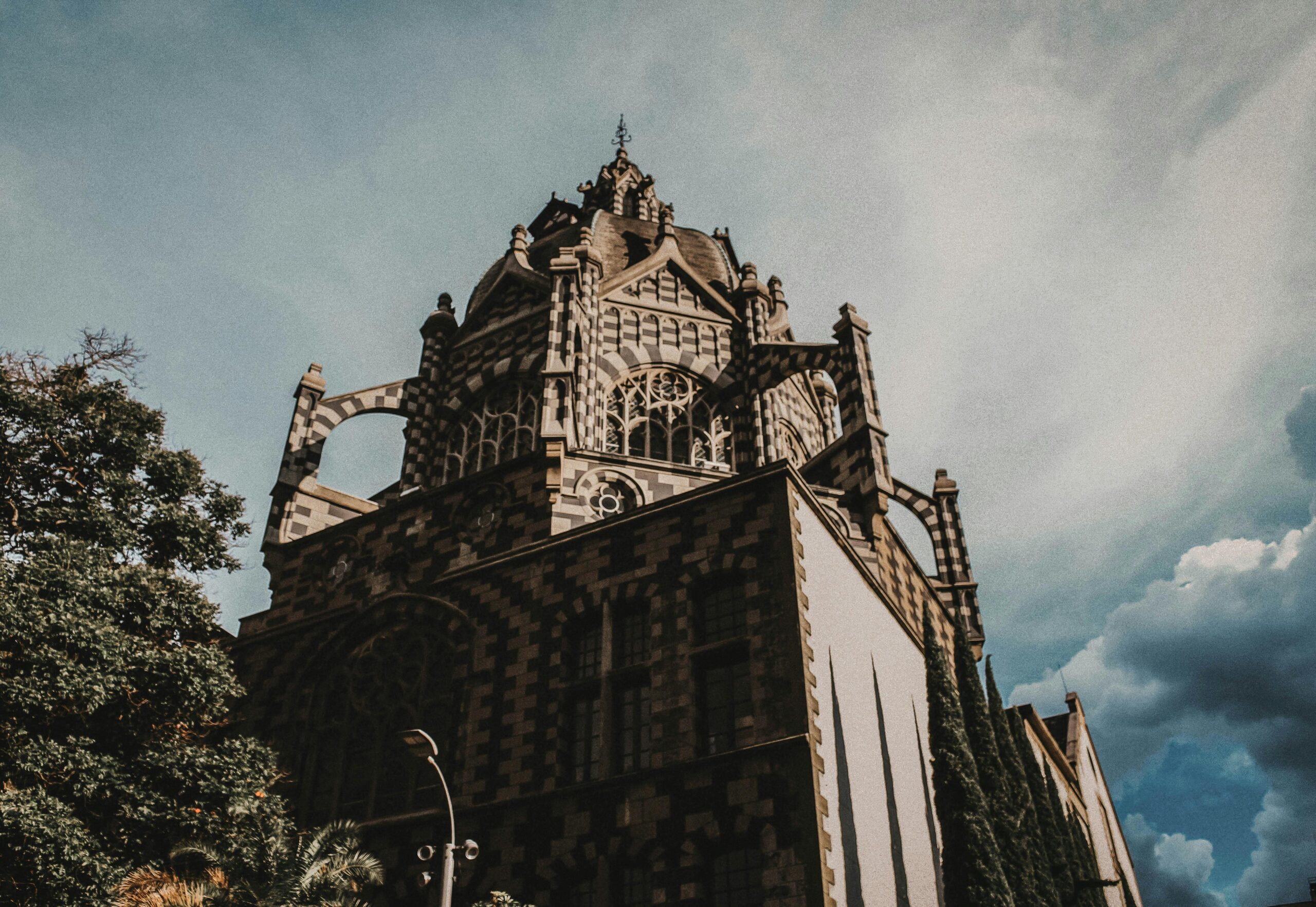 Elegant neoclassical building in Medellín showcasing intricate gothic design under the bright sky.